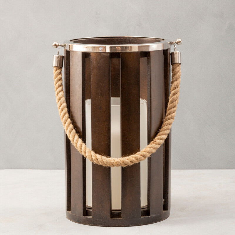 Decorative metal lantern with rope handle on a neutral background