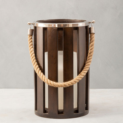 Decorative metal lantern with rope handle on a neutral background
