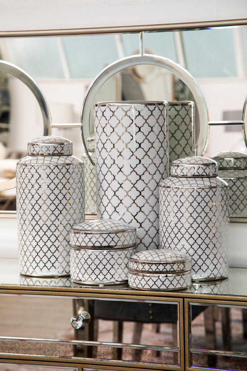 Decorative jars with lattice patterns on a reflective surface