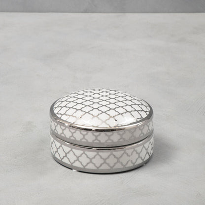 Decorative silver box with a textured pattern on a gray surface