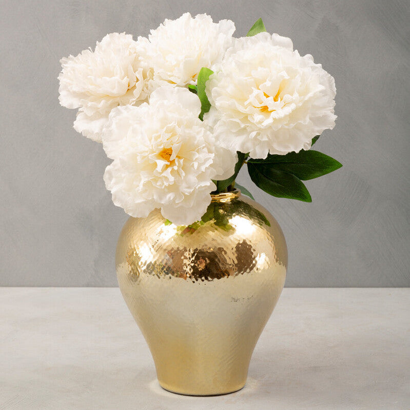 Gold vase with white flowers on a gray background