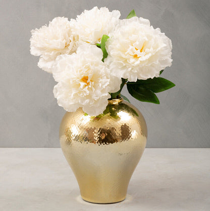 Gold vase with white flowers on a gray background