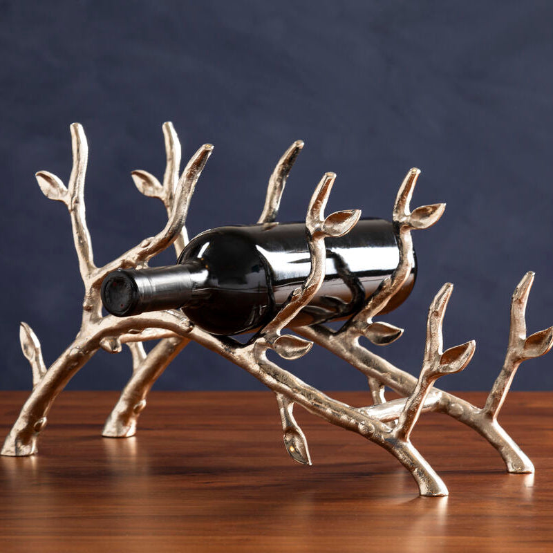 Decorative wine bottle holder with a bottle on a wooden surface and dark background