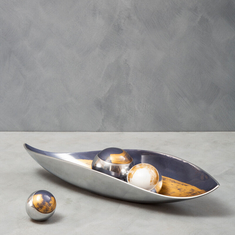 Decorative bowl with spherical objects on a gray surface and background