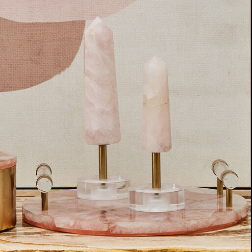 Decorative candle holder with pink candles on a wooden surface