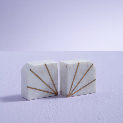 Two white marble blocks with gold accents on a light purple background