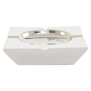 White ceramic ashtray with silver interior on a white background