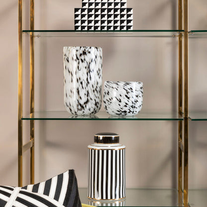 Glass shelves with black and white decor items against a neutral background