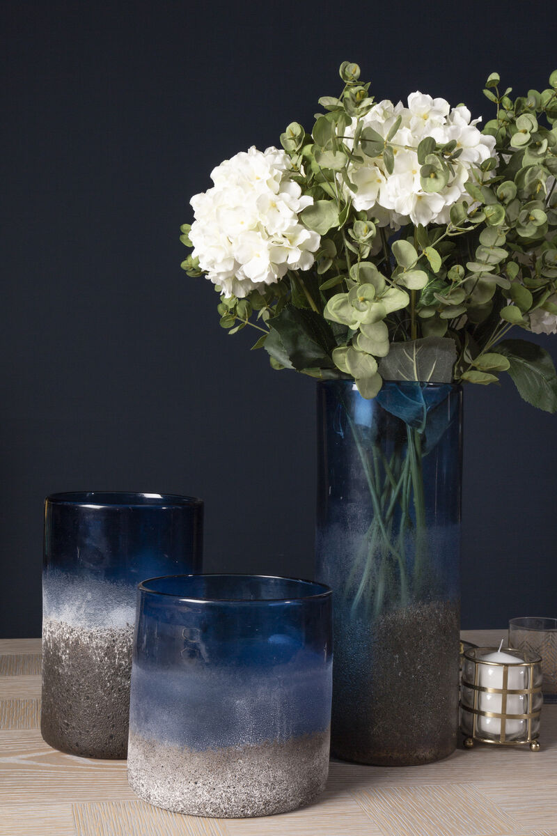 Vases with gradient blue and gray design and a bouquet of white flowers on a dark background