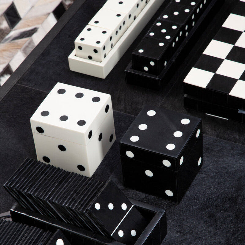 Black and white dice and dominoes on a dark surface