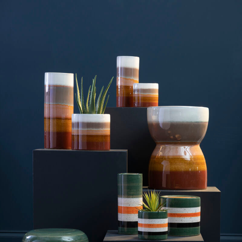 Collection of ceramic planters with striped patterns on a dark background
