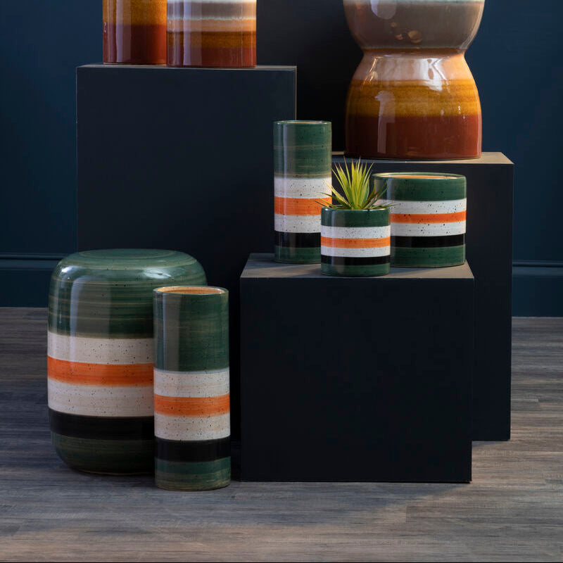 Collection of ceramic planters with striped patterns on a dark background
