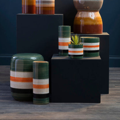 Collection of ceramic planters with striped patterns on a dark background