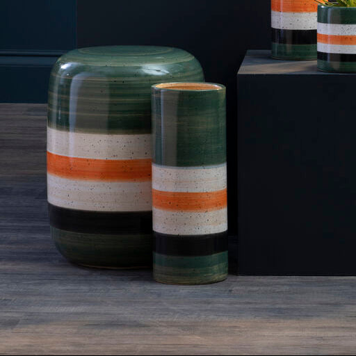 Collection of ceramic planters with striped patterns on a dark background