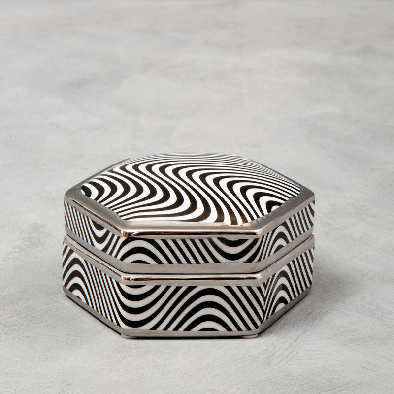 Hexagonal box with black and white wavy pattern on a light gray surface