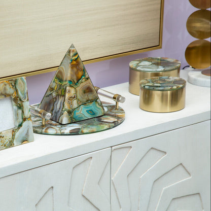 Decorative items including a marble-patterned photo frame and pyramid on a white surface.