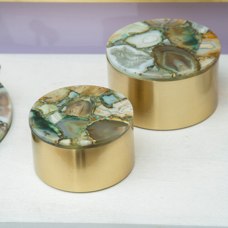 Two decorative boxes with green and brown stone lids on gold bases.