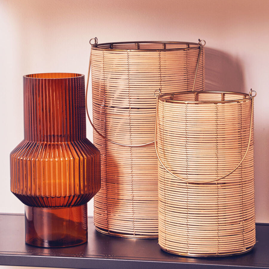 Three decorative lamps with ribbed textures on a shelf against a light pink wall.
