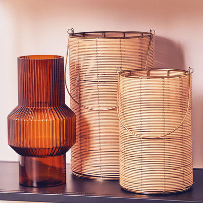 Three decorative lamps with ribbed textures on a shelf against a light pink wall.