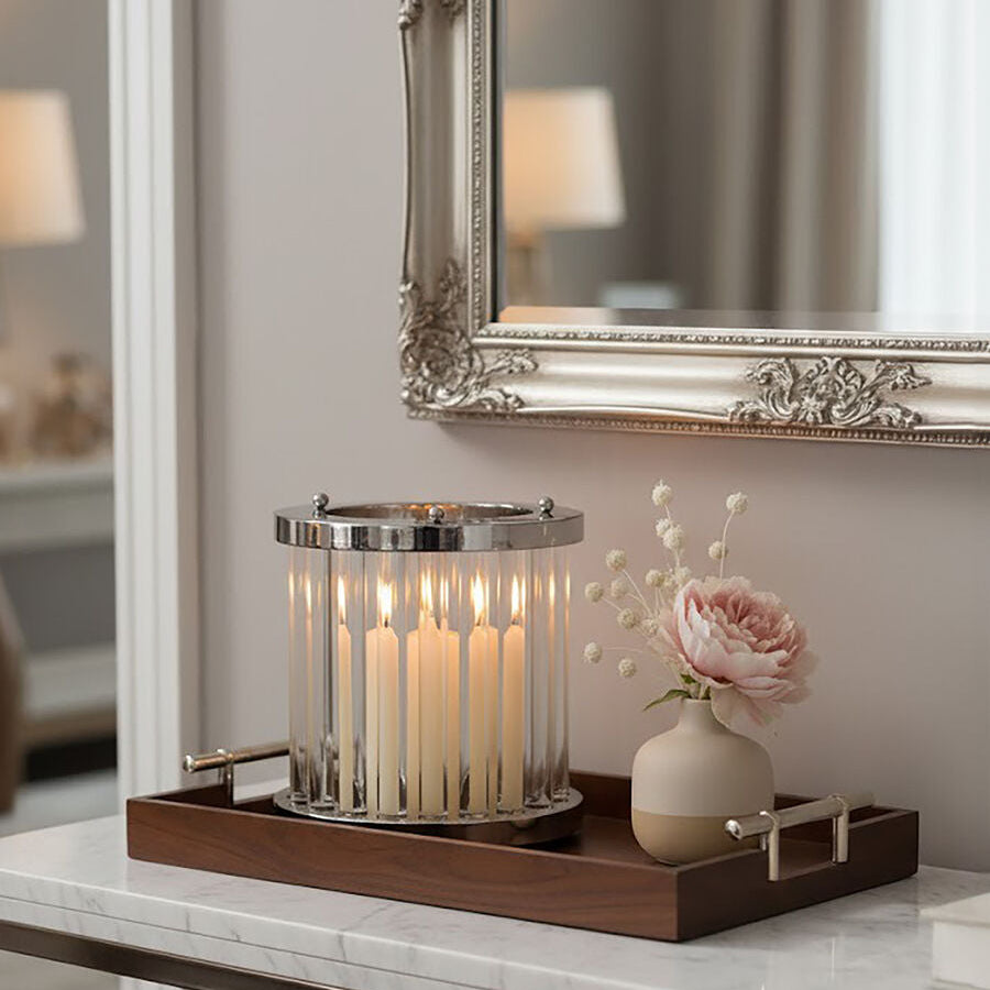 Decorative tray with candles and a vase on a marble surface, featuring a mirror with an ornate frame.