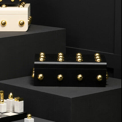 Luxury jewelry display with black and gold boxes on a dark background