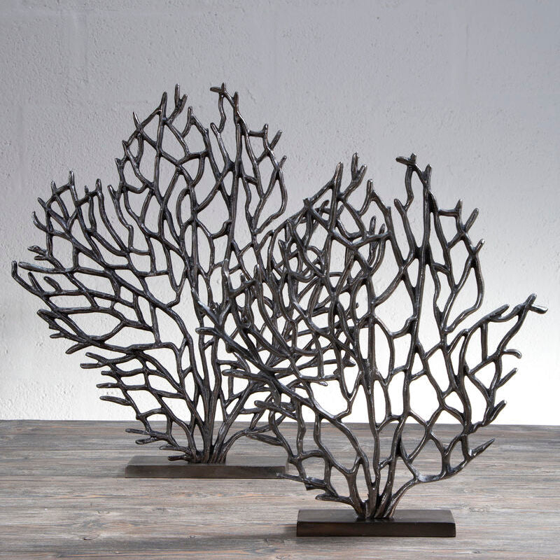Decorative metal coral sculptures on a wooden surface with a gray background
