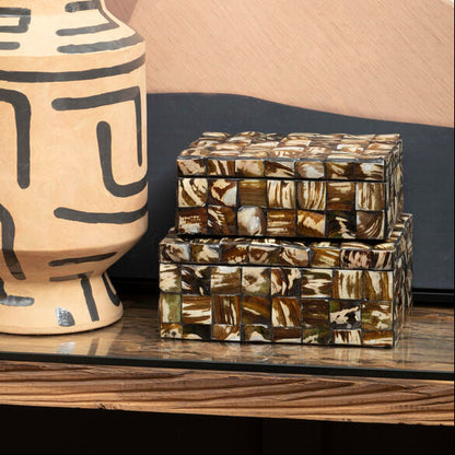 Ceramic vase with geometric patterns on a shelf against a abstract wall.