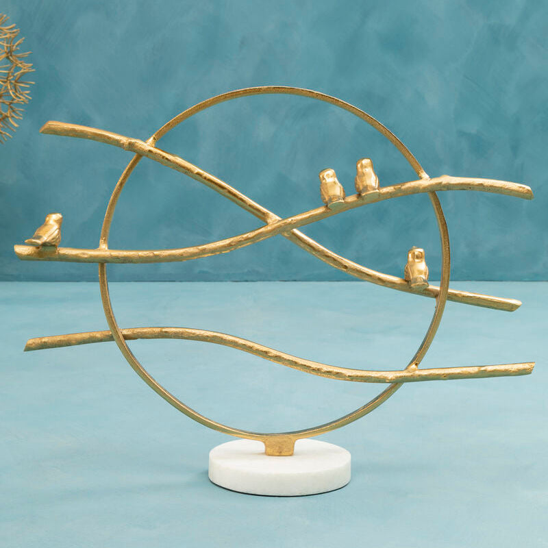 Decorative sculpture with gold branches and small figures on a blue background