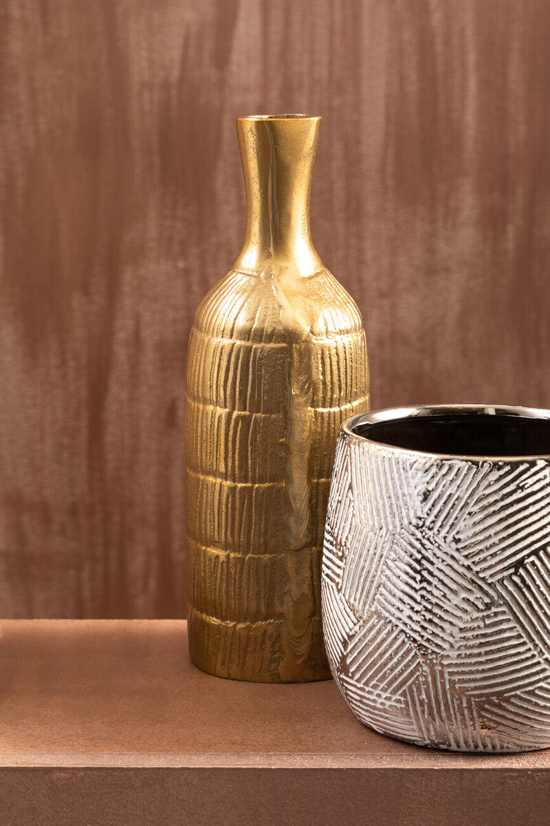 Gold and silver textured vases on a brown surface with a brown background