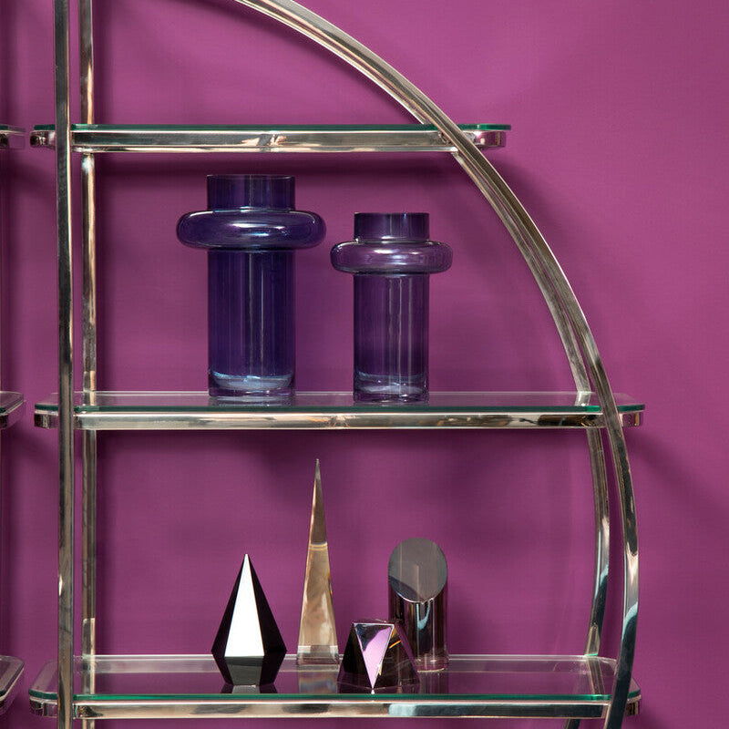 Chrome shelf with glass shelves against a purple wall