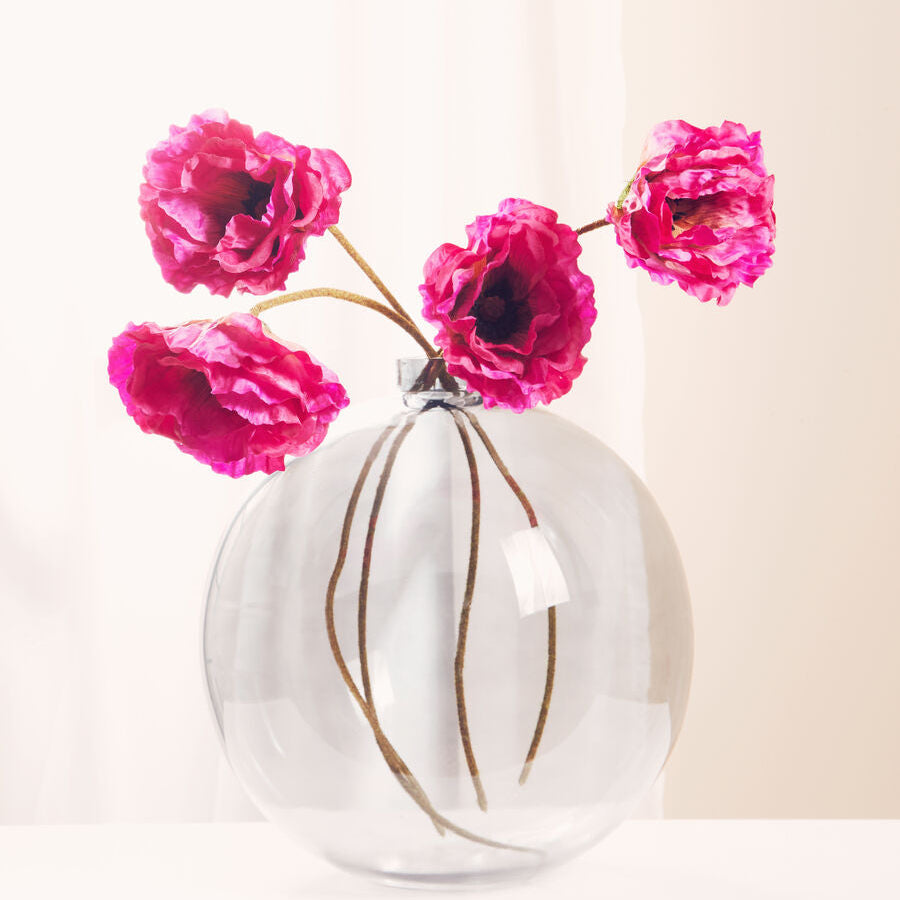 Clear glass vase with pink flowers on a light background