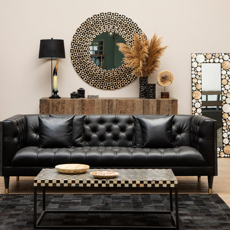 Modern living room with black leather sofa, wooden coffee table, and decorative mirrors.