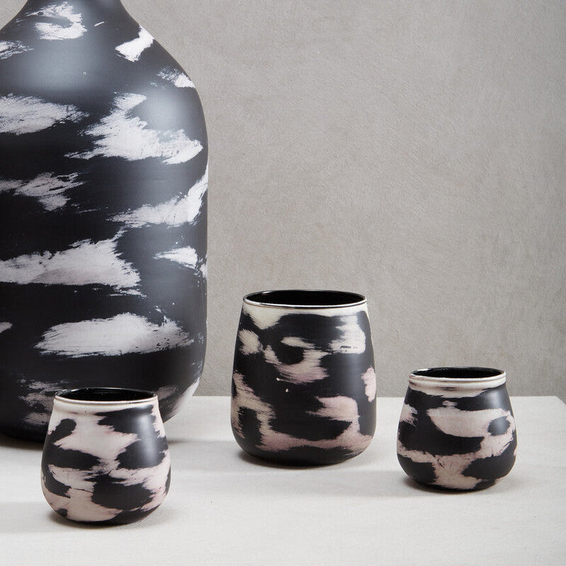 Set of black and white ceramic vases on a gray background