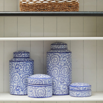 Set of blue and white patterned ceramic jars on a shelf with a woven basket above.