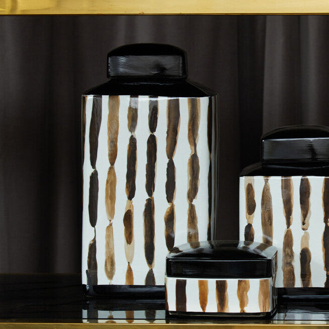 Decorative jars with black and white pattern on a dark background