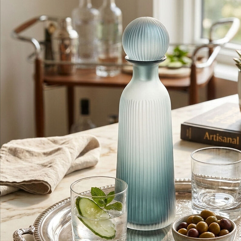 Decorative glass carafe on a table with glasses and snacks