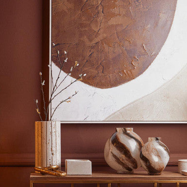 Decorative setup with vases, a vase, and a wall art piece in a room.