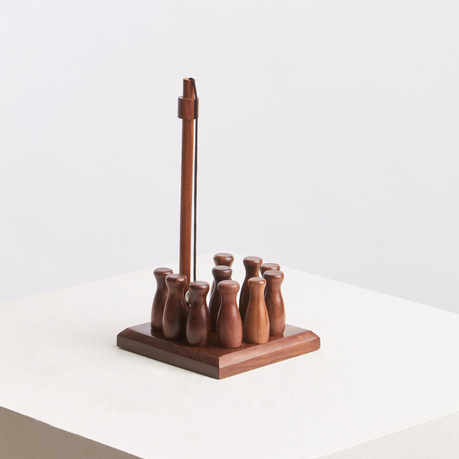 Wooden bottle opener with six bottles on a white surface