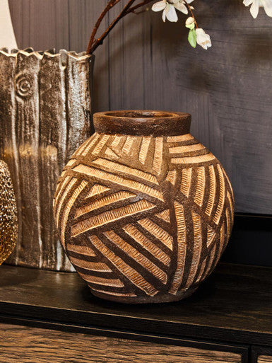 Decorative terracotta vase with geometric pattern on a wooden surface