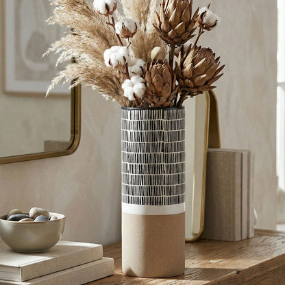 Decorative vase with dried flowers on a wooden table