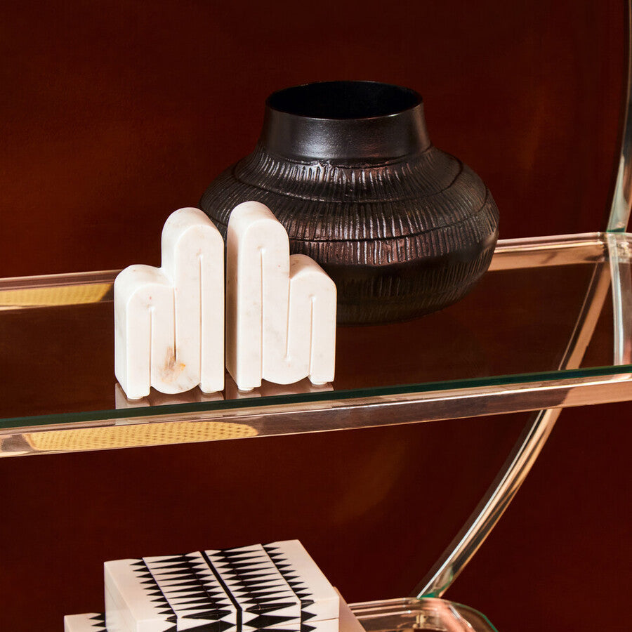 Decorative items on a glass shelf with a dark background