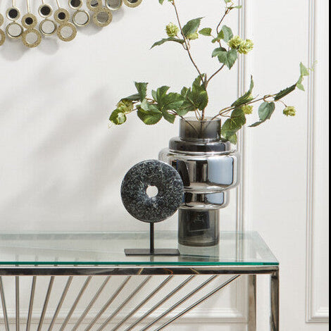 Decorative wall mirror with a glass console table below it.