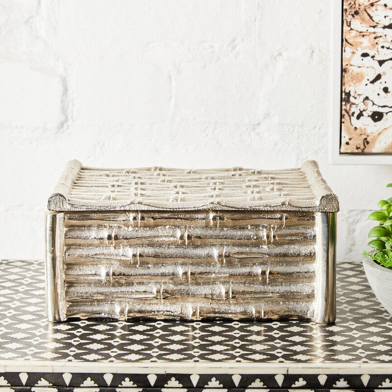 Wooden storage box on a patterned floor with a white wall and abstract art in the background