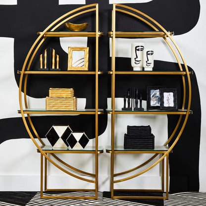 Gold circular shelving unit with decorative items against a black and white abstract background