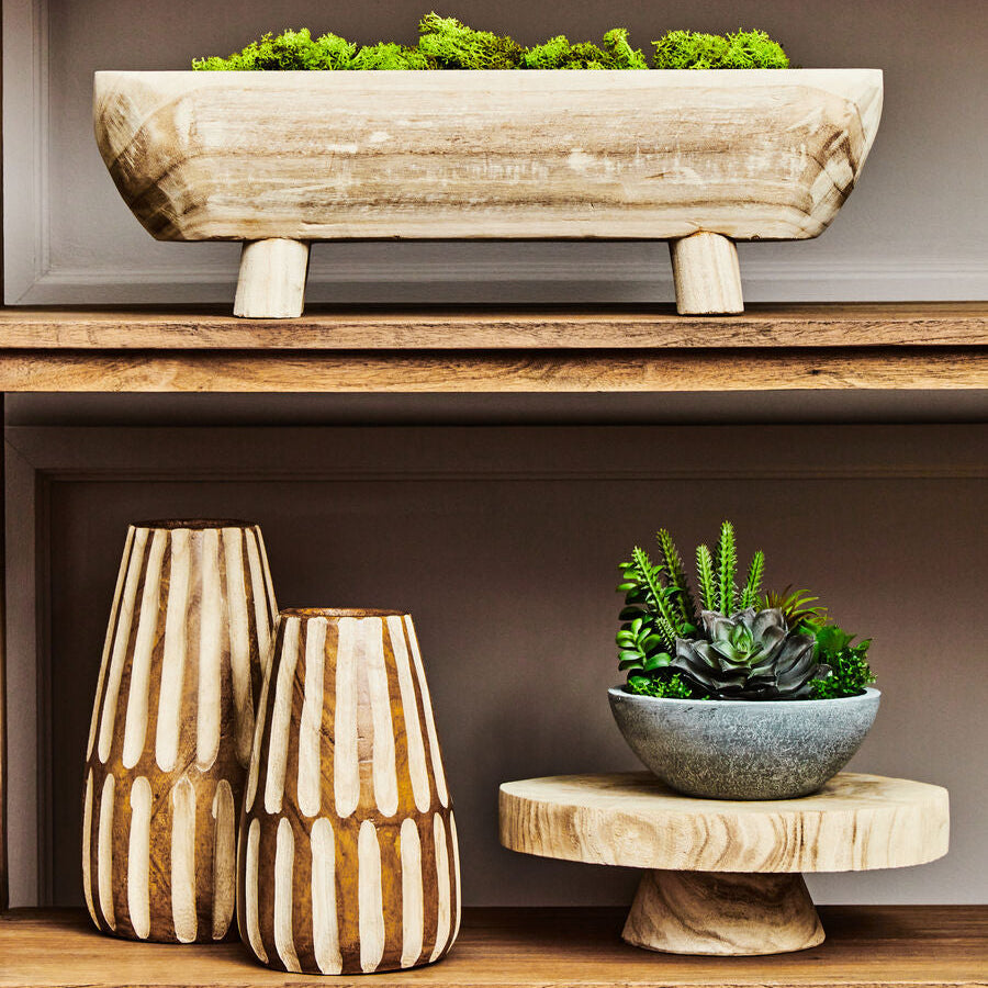 Decorative wooden planters and vases on a shelf against a neutral background