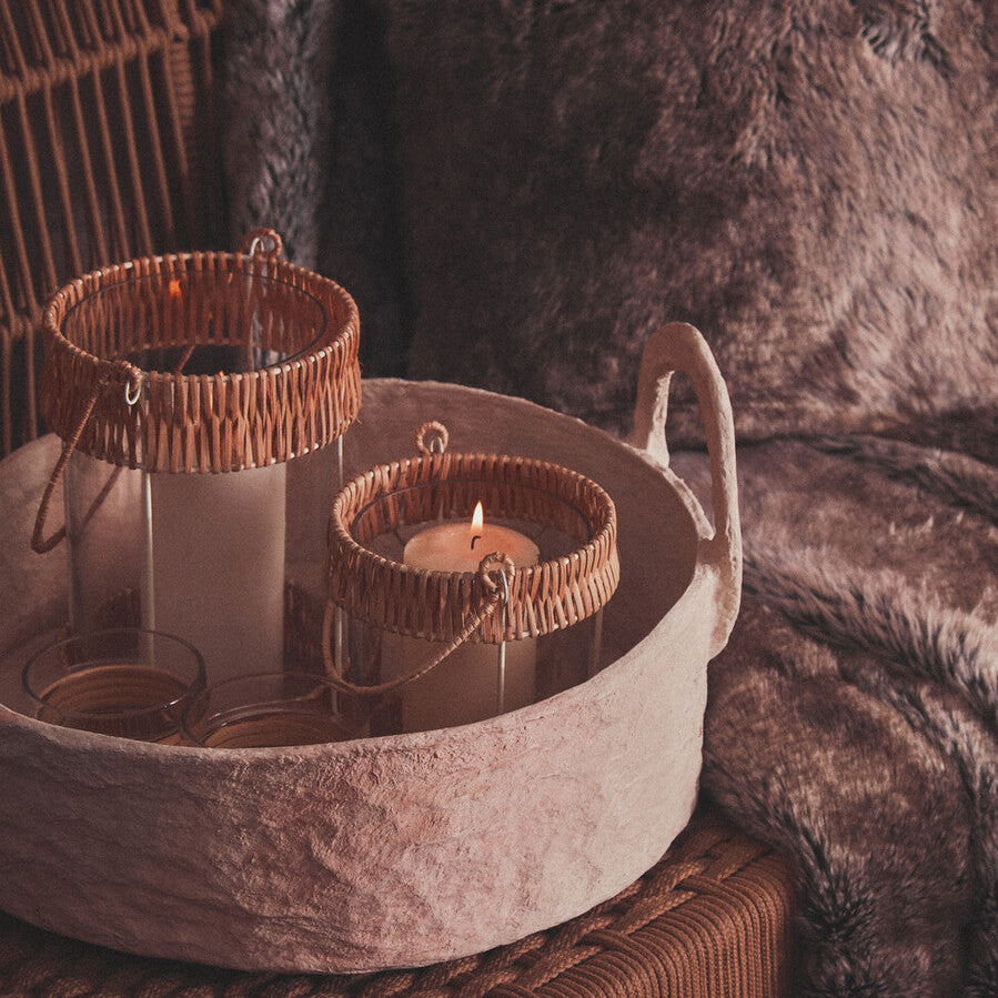 Decorative stone bowl with candles on a textured surface