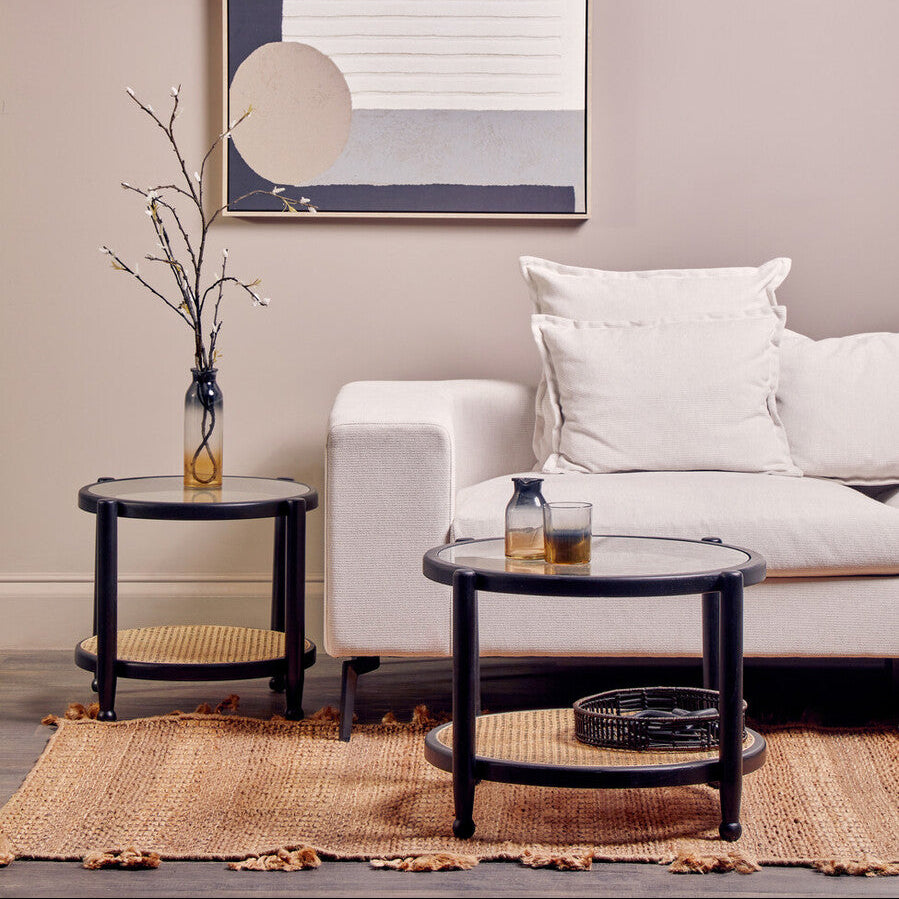 Living room with a white sofa, black side table, and abstract art on the wall.