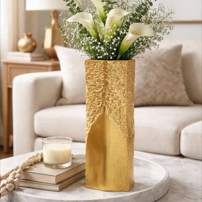 Gold vase with flowers on a coffee table in a living room setting
