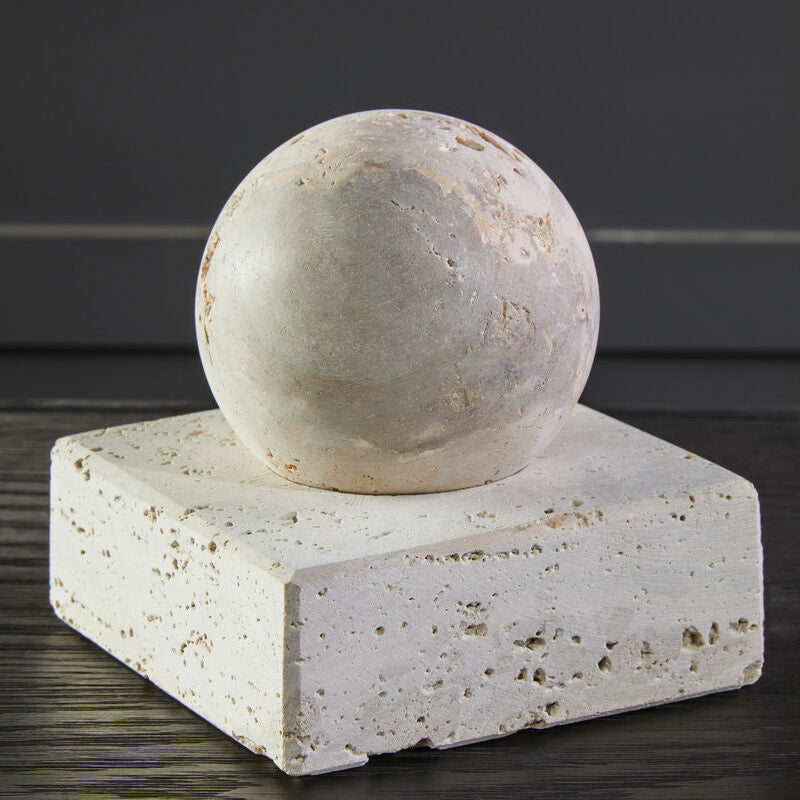 Stone sphere on a square stone platform with a dark background