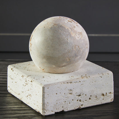 Stone sphere on a square stone platform with a dark background